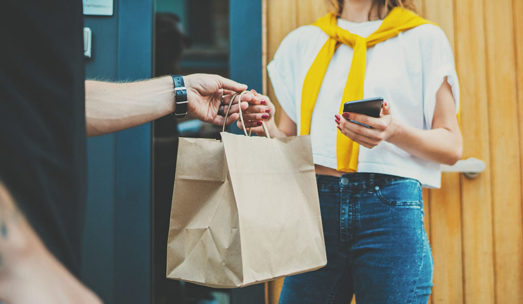 woman receiving food in delivery bag